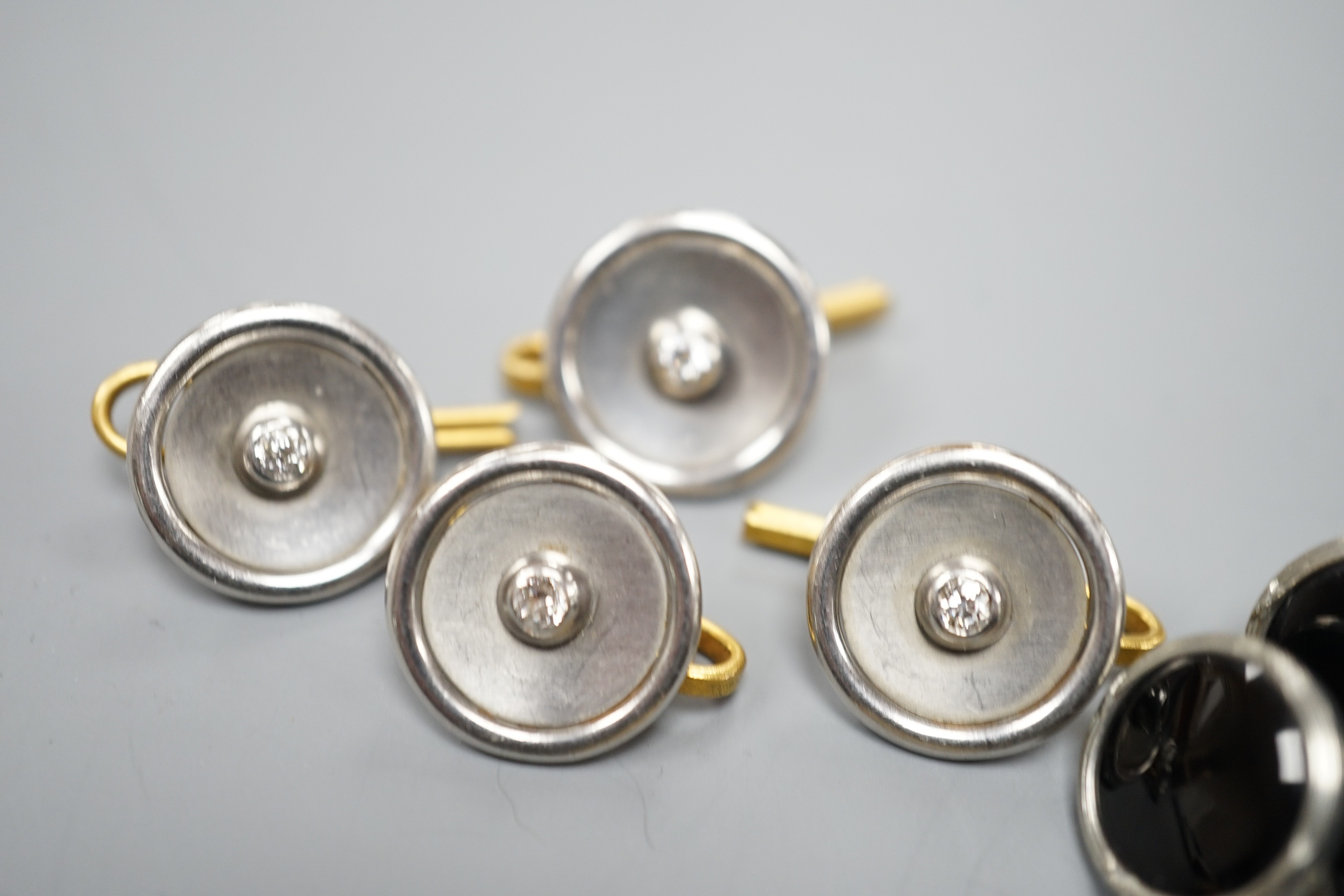 A pair of small pair of yellow and white metal diamond set cufflinks and four similar dress studs and four other yellow metal and black enamel? dress studs, gross weight 22.6 grams